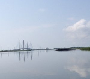 The Indian River Inlet Bridge reflecting in calm water.